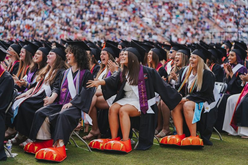 Rachel Mirsen, left, Masan Brown, and Abby Stewart react as they are "revealed" as students who portrayed the HokieBird during their time at Virginia Tech